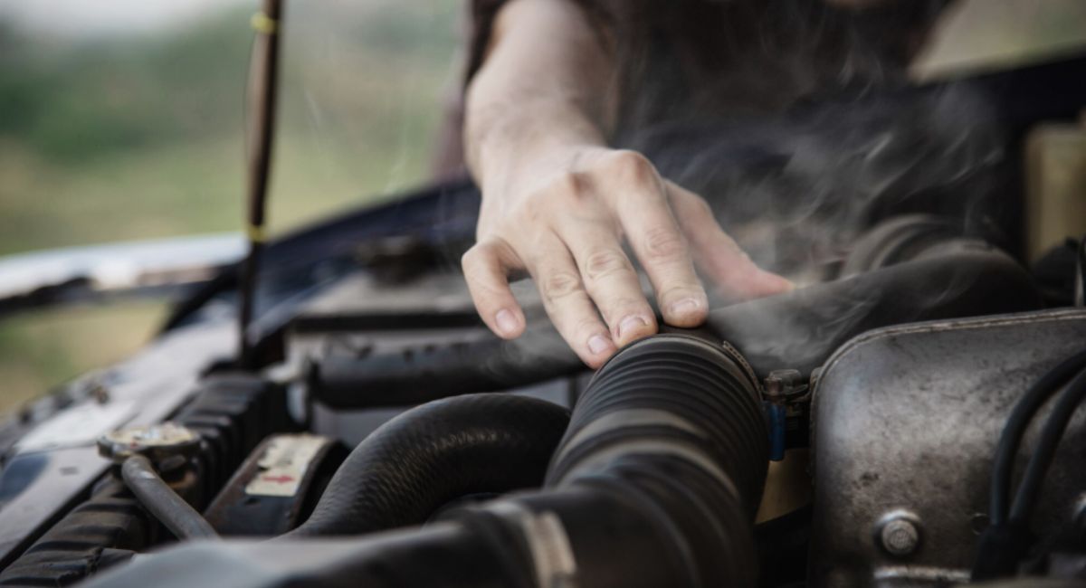 hombre revisa los motivos del sobrecalentamiento de motor del carro
